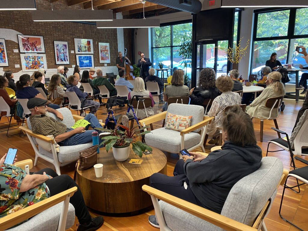 a large informal audience listens to poetry